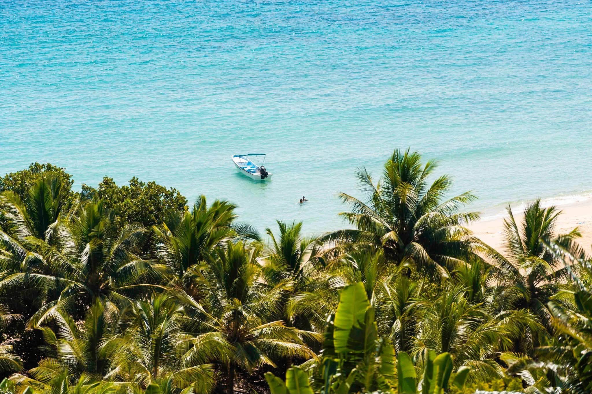 Palmiers, plage et bateau dans un lagon malgache